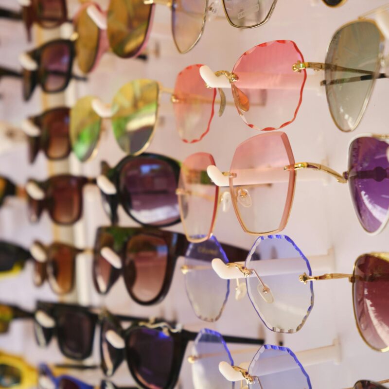 A vibrant array of stylish sunglasses showcased on a display stand.