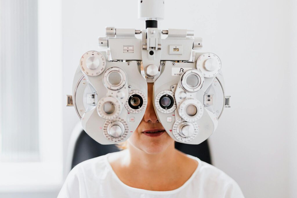Detailed view of a person undergoing an eye exam with a phoropter in a modern clinic.