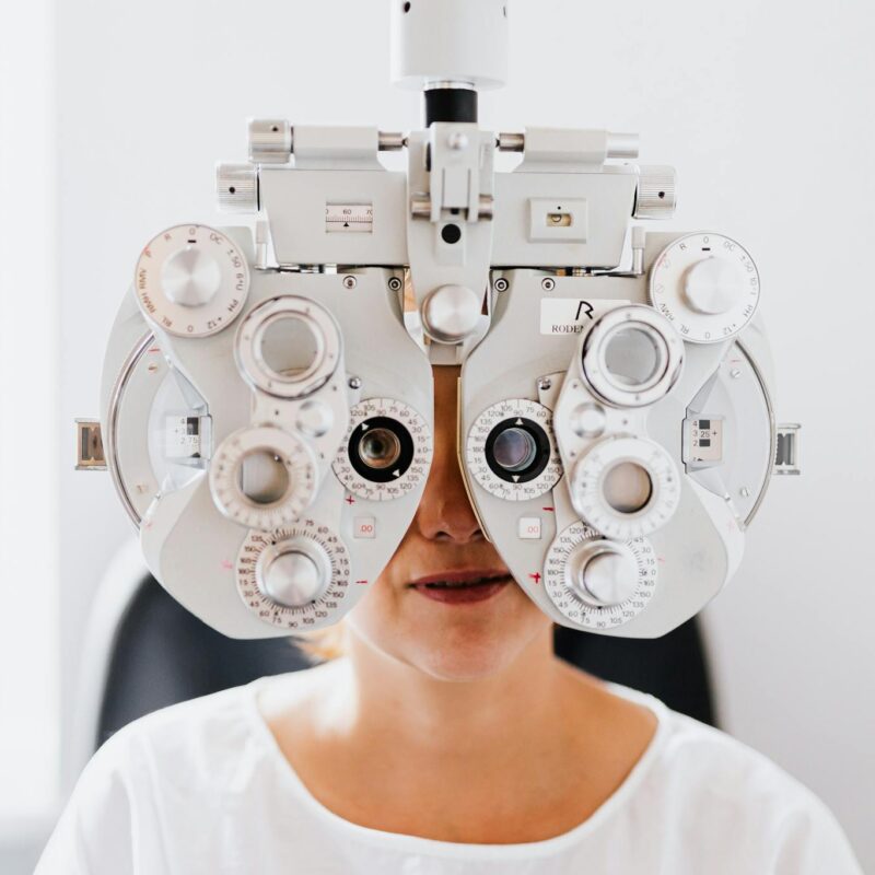 Detailed view of a person undergoing an eye exam with a phoropter in a modern clinic.