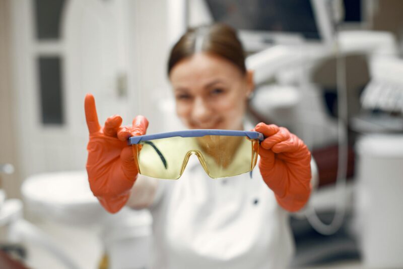 Focused dental worker showcasing protective eyewear in clinic.