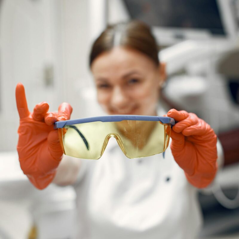 Focused dental worker showcasing protective eyewear in clinic.